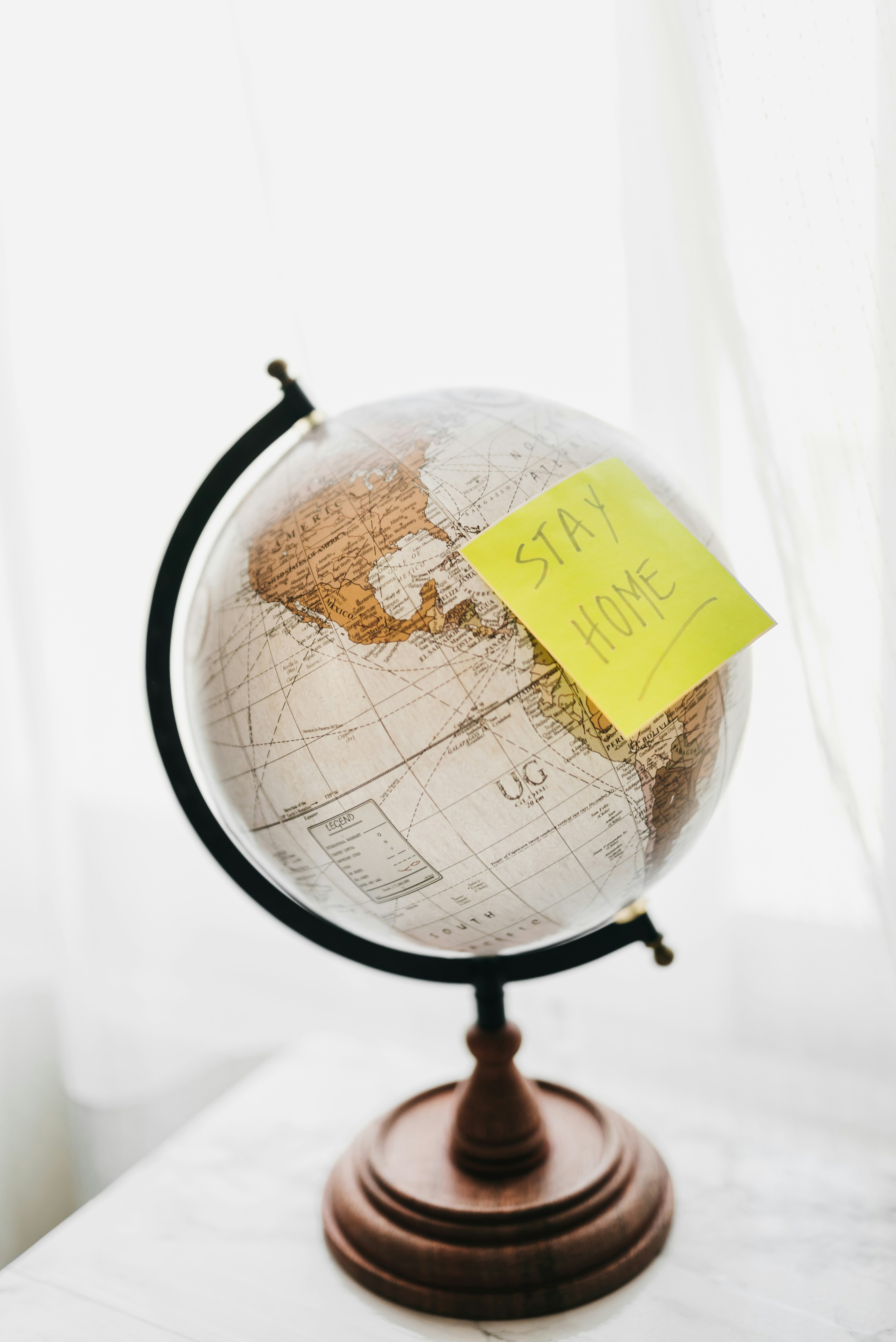 Globe with post it note saying stay home